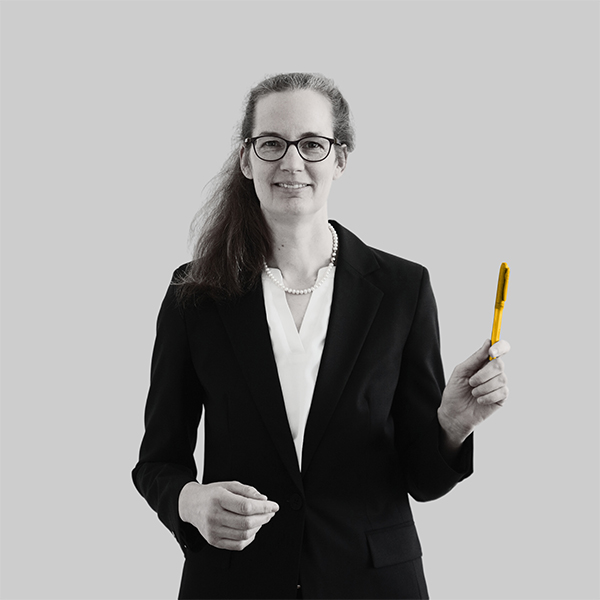 Team-rheform - Christina Weber, Dipl. Ing. und Dipl. W. Ing., Bereichsleiterin Zielorientierte Bedarfsplanung Standortkonzepte und Nachhaltige Immobilienentwicklung Gebäudeanalyse hält einen Stift in der Hand