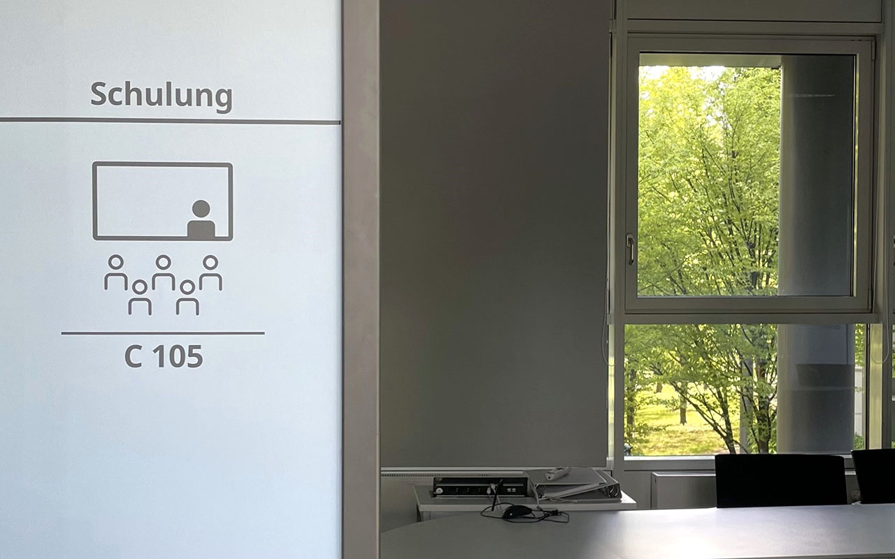 New-Work - ein Icon weist einen Raum für Schulungen aus. Der blaue Hintergrund zeigt, dass es sich hier um einen Raum für konzentriertes Arbeiten handelt.