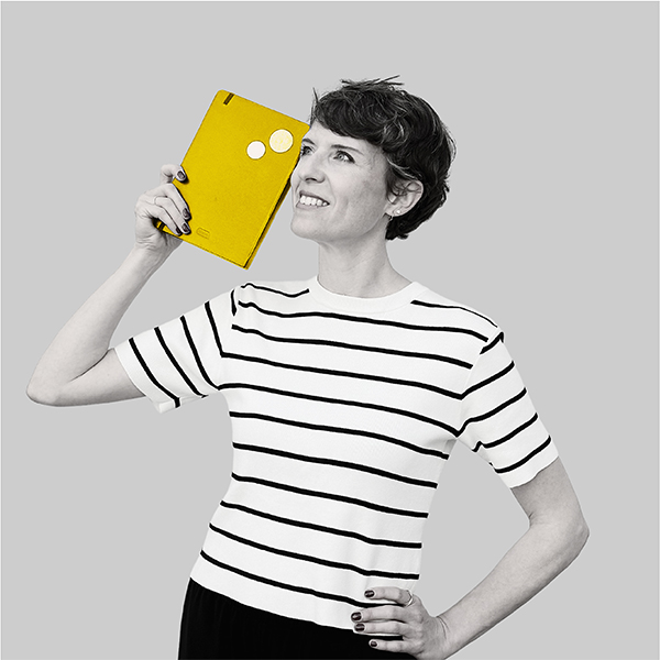Team-rheform - Kim Florence Rust, Dipl. Ing. Innenarchitektur, Bereichsleiterin Innovative Arbeitswelten Konzerne und Mittelstand II hält ein Notizbuch neben ihren Kopf.