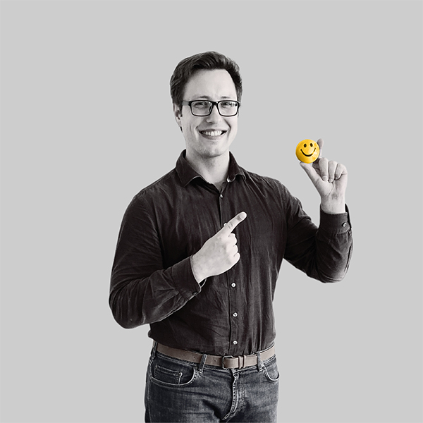 Team-rheform - Mark Maslowski B.Sc. Volkswirtschaftslehre aus dem Team Data Lab hält einen kleinen Ball mit Smiley mit der linken Hand und zeigt mit dem rechten Zeigefinger darauf