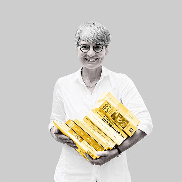 Team-rheform - Sandra Butscher aus der Abteilung Kommunikation und Marketing hält einen großen Stapel Bücher in beiden Händen