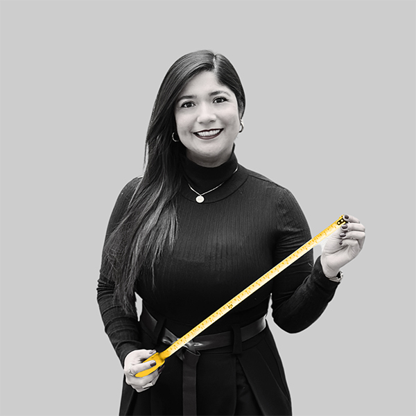 Team-rheform - Yuliana Giselle Vargas Galvis, B.A. Architektur von den Innovativen Arbeitswelten Konzerne und Mittelstand III hält ein aufgerolltes Maßband in beiden Händen