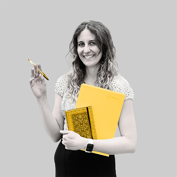 Team-rheform - Yvonne Ramp, M.A. Komparatistik, M.A. Übersetzung aus dem Team Kommunikation und Marketing hält zwei Notizbücher auf Hüfthöhe, in der anderen Hand hält sie einen Stift