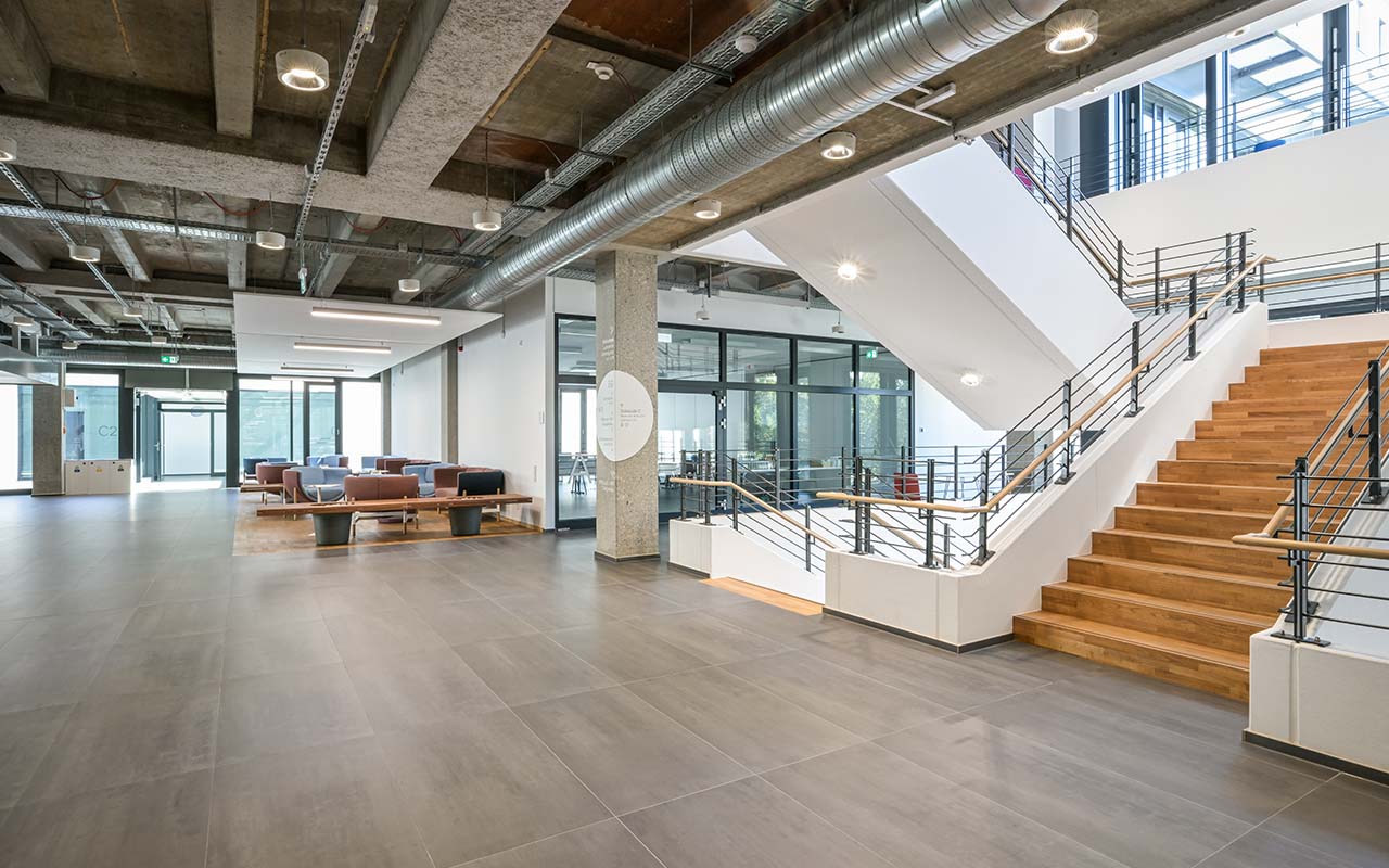 Evenagelische-Hochschule-Freiburg die Innentotale des Foyers mit Treppe nach der Modernisierung des Altbaus nach rheform-Planung