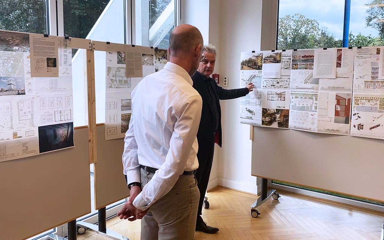 Jurysitzung-campus³-Preis - Juror Boris-Schade Bünsow erklärt Joachim Heintze seine Auswahl eines Planes