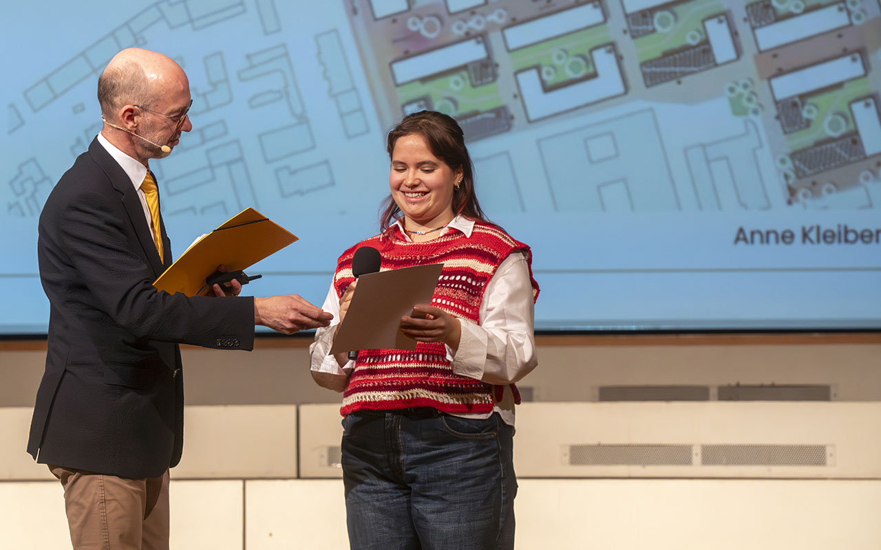 Preisverleihung-campus³-Preis-2025: Anne Kleiber, Gewinnerin in der Kategorie Campusentwicklung, nimmt von Joachim Heintze ihre Urkunde entgegen.