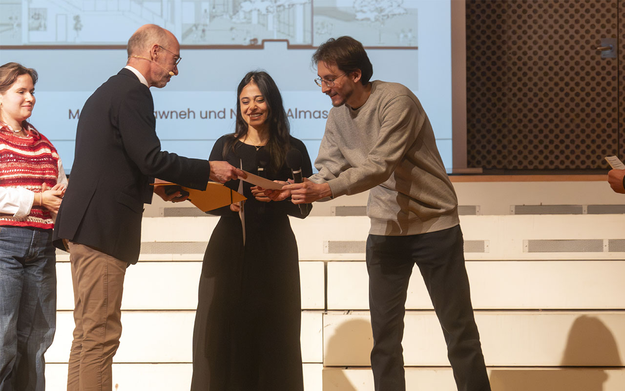 Preisverleihung-campus³-Preis-2025: Gewinnerinnen in der Kategorie Architektur, Marah Altarawneh und Nawras Almasri, nehmen von Joachim Heintze (rheform) ihre Urkunden entgegen.